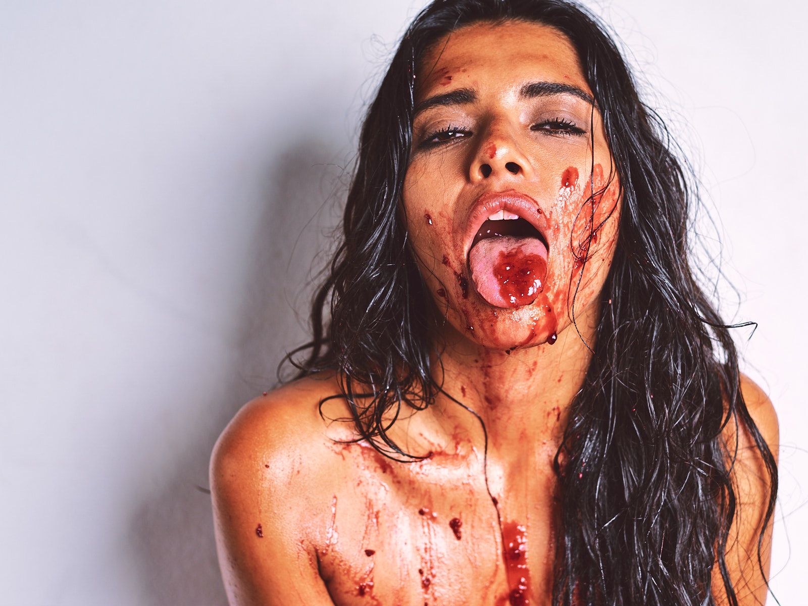 African Beauty nude with a long braid, smearing white cream across her tattooed dark skin and intimate areas