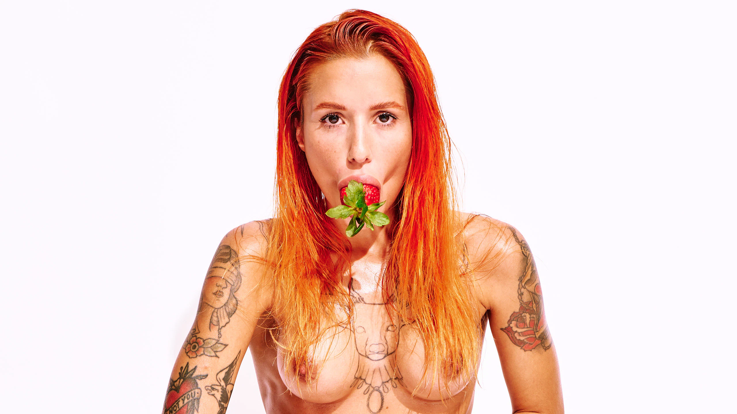 Tattooed red-haired model Ana Almeida in playful nude art photography.