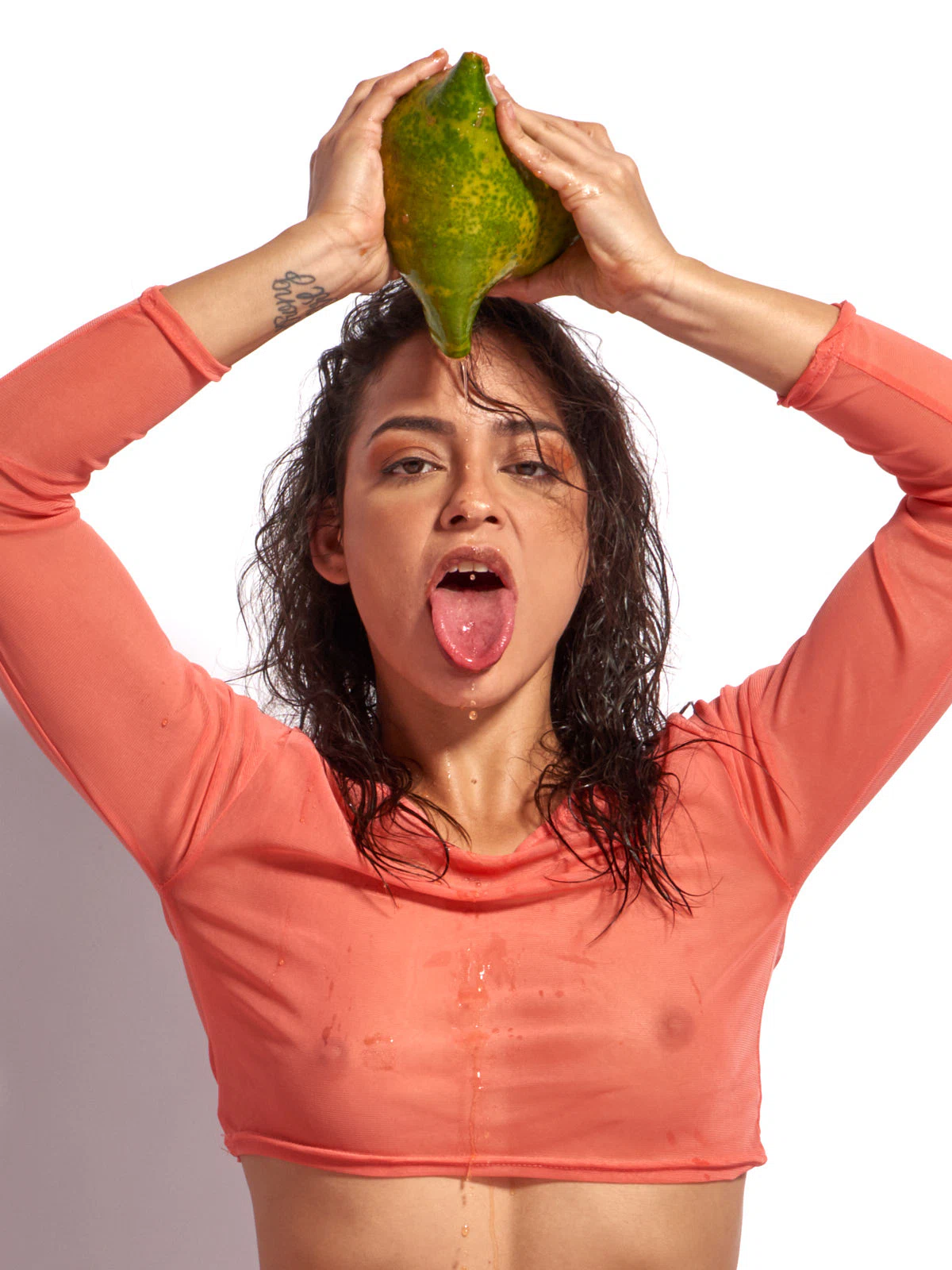 Joy Lamore nude with sheer crop top interacting with tropical fruit in erotic fine art