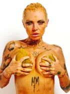 Lu Epic fully nude in an erotic art series eating and smearing papaya fruit across her face and body