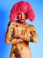 Tattooed nude model in the Red Rabbit series wearing red fur hat with rabbit ears