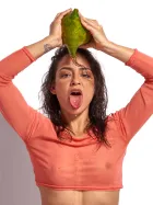 Joy Lamore nude with sheer crop top interacting with tropical fruit in erotic fine art