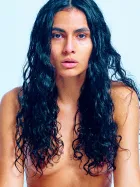 Brown Sugar nude on a soft blue background, captured in elegant, flowing movement and cinematic light