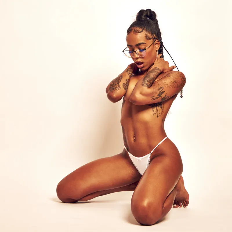 Artistic nude photography highlighting African Beauty’s tattooed petite body