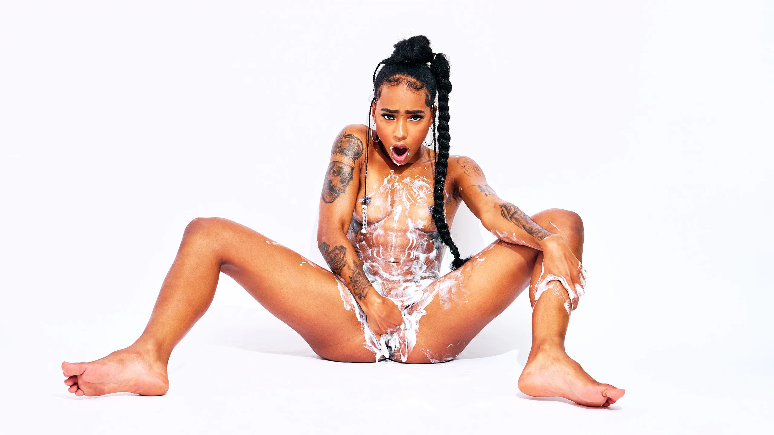 African Beauty nude, long braid, smearing cream across torso and intimate areas